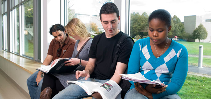 four students with books 450x300px used on academic affairs chelsea campus page