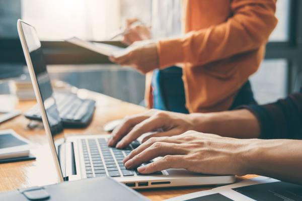 hands typing on a computer