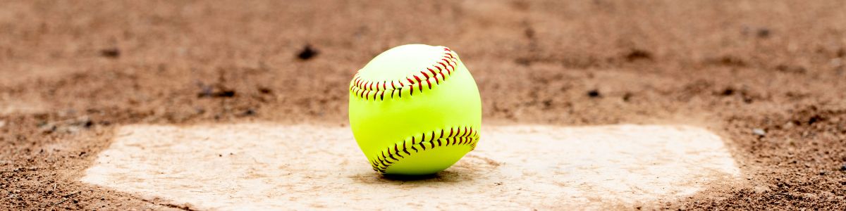 A softball on a baseball field plate 