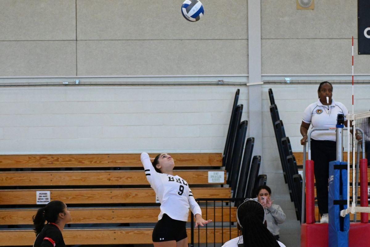 Volleyball player at a bhcc game serving the ball