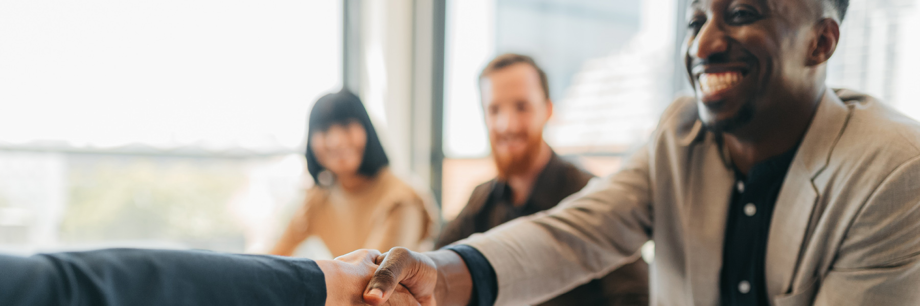 Students in a classroom, and one student is shaking hands with an unseen person.