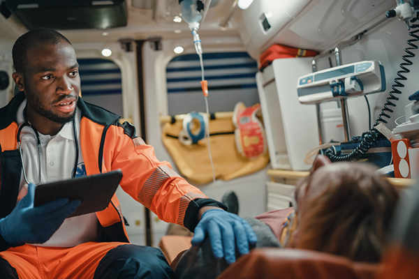 EMT with patient on stretcher in back of an ambulance