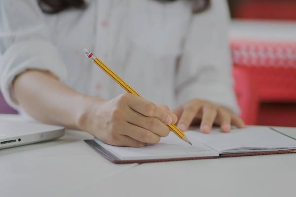 A person writing on a notebook