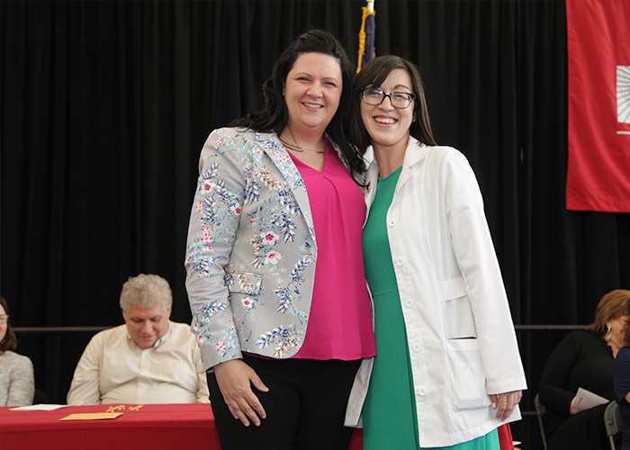 student posing with faculty member