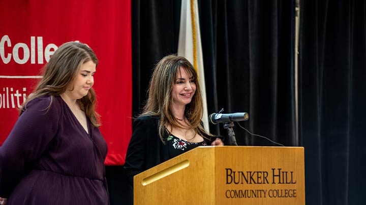 nursing student at podium with staff member