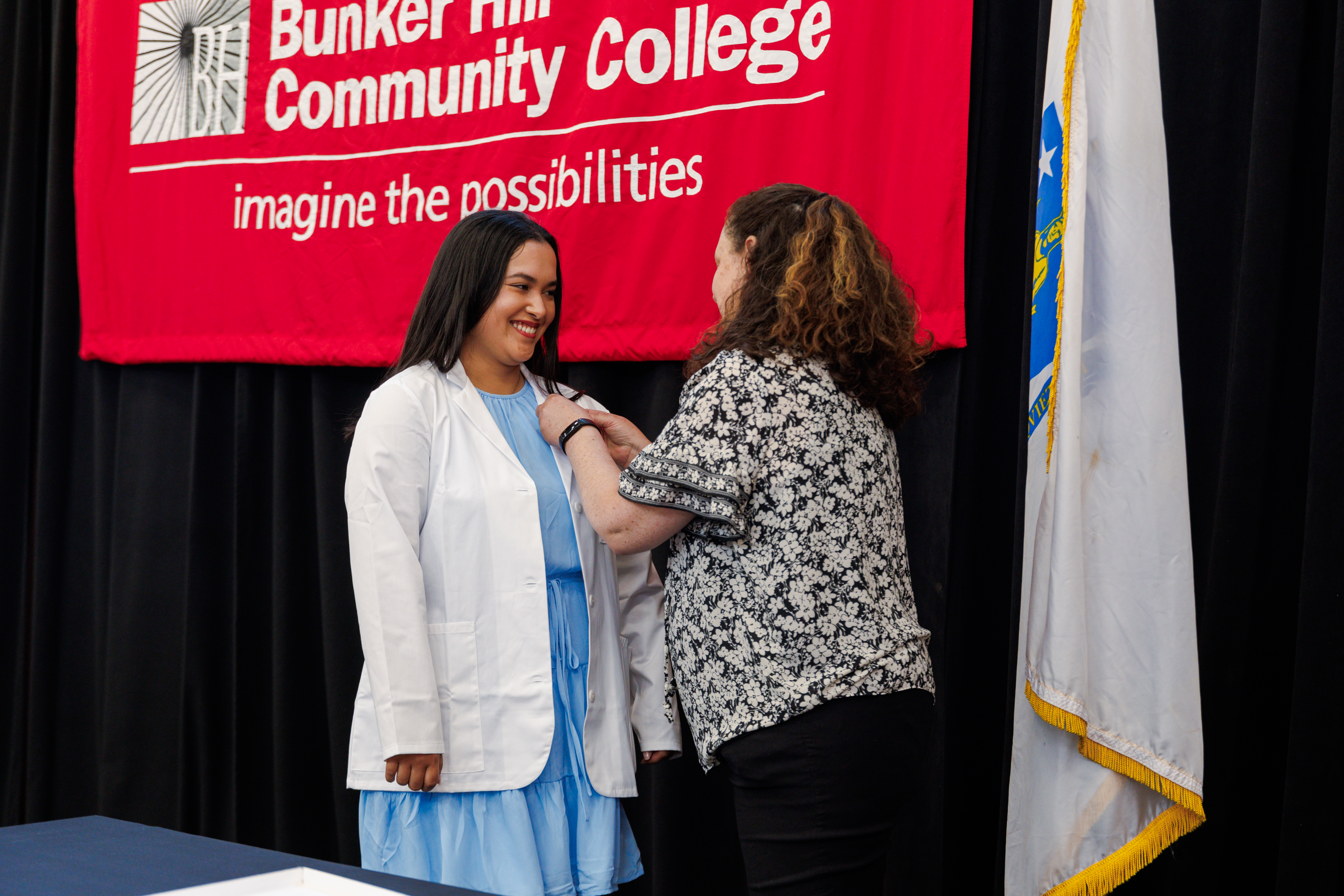 Pin being placed on graduating student