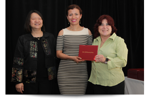 thumbnail of female student receiving diploma from Toni and president eddinger 