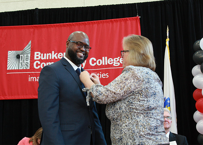 smiling male student receives his nurse pin