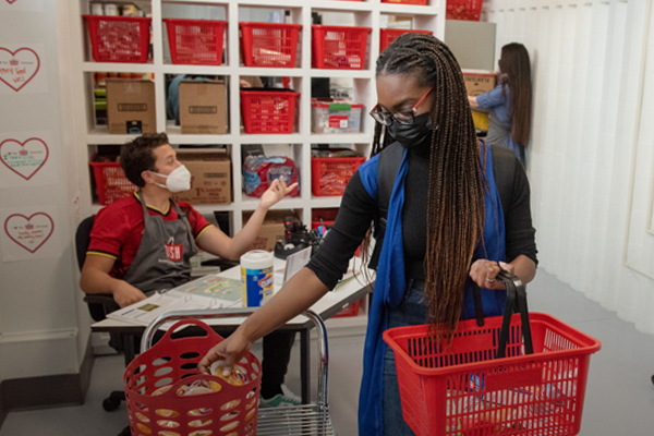 Woman holding a basket grabbing groceries