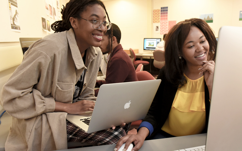 Staff and student in front of a computer