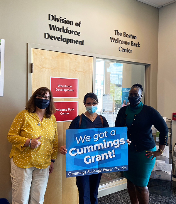 three people holding the Cummings Grant banner