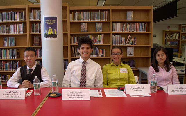 four young students sitting at a desk