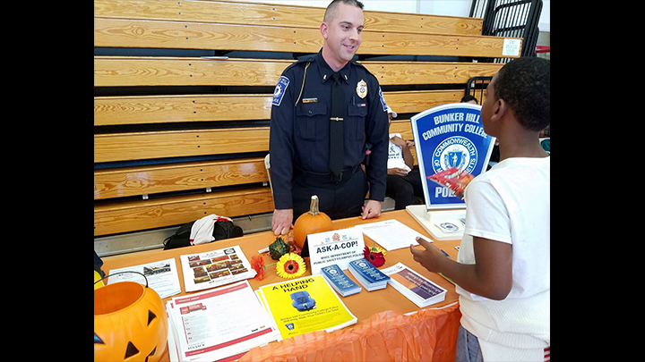 Cop on the information booth attending to a kid