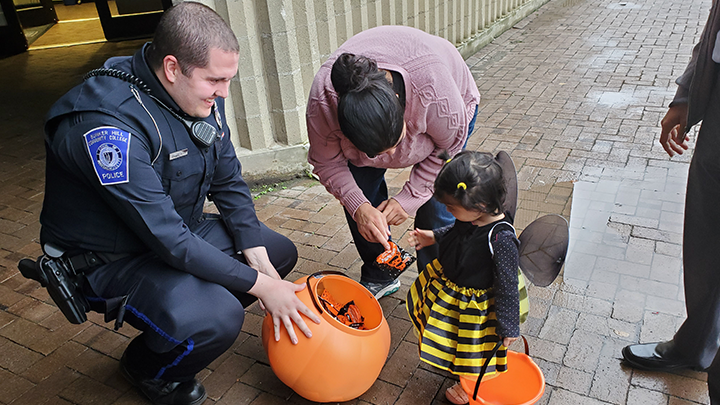 Cop participating in a trick or treats with a kid