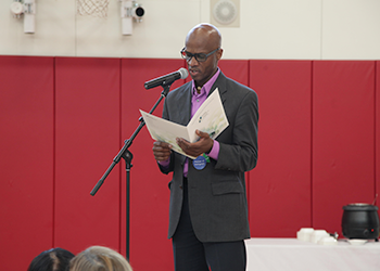 faculty member speaking at microphone on stage