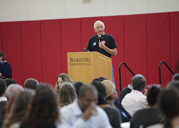 faculty member speaking at podium on stage