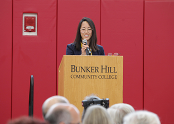 faculty member speaking at podium on stage